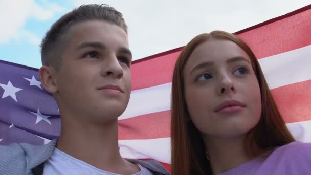 Un par de adolescentes cubrieron la bandera nacional de Estados Unidos, tocando la frente, disfrutando del pasatiempo — Vídeos de Stock