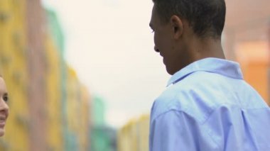 Siyah genç adam, sevgili kız arkadaşını, genç çiftin kucaklaşmasını, flört etmesini görmekten mutlu.