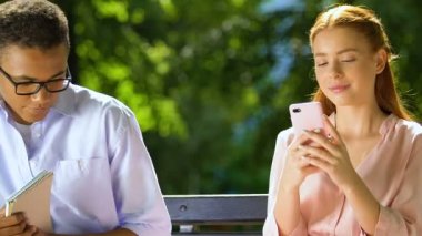 Zenci genç, hoş bir kızla tanışmaya çalışıyor. Telefonu kaydırıyor, adamı görmezden geliyor.