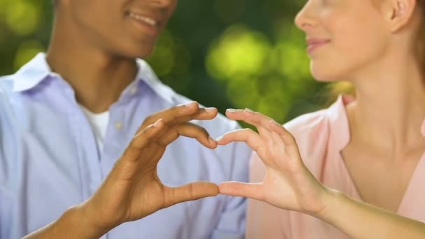 Feliz pareja adolescente haciendo que el corazón cante con los dedos, el amor verdadero y las relaciones — Vídeo de stock