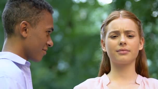 Рыжая девушка отвергает поцелуй черного мальчика, предвзятое отношение к расовым различиям — стоковое видео