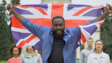 Öfkeli siyah adam Büyük Britanya bayrağı kaldırıyor, Brexit protesto, göç krizi