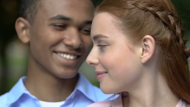 Dwurasowa para uśmiechnięta razem, pokazująca papierowe serce przed kamerą, romans — Wideo stockowe