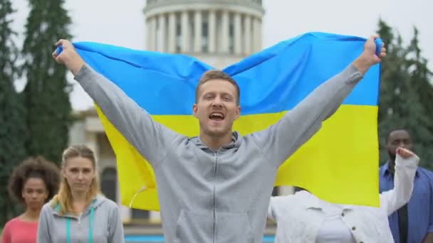 Счастливая молодежь, поднимающая украинский флаг, диаспору в Вашингтоне, патриотический народ — стоковое видео