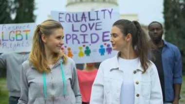 Olumlu kalabalık Lgbt hakları ve gurur yürüyüşü için gökkuşağı sembolleri ve posterleri kaldırıyor
