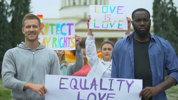 Hombre elevando el cartel del orgullo de amor por la igualdad junto con activistas LGBT, marcha del orgullo — Vídeos de Stock