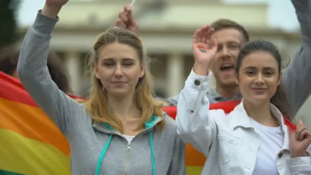 Attivisti che saltano cantando slogan LGBT, mostrando simboli arcobaleno dipinti, bandiere — Video Stock