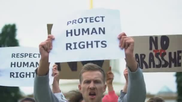 Aktivisten skandieren Menschenrechtsparolen mit Transparenten und demonstrieren gegen Belästigung — Stockvideo