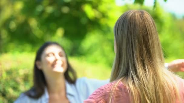 Chica morena feliz de ver a su amigo rubio, chica abrazando al aire libre, primer plano — Vídeo de stock