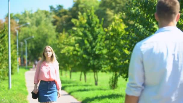 A srác bámulja a szőke sétál a parkban a barátnőjével, szépség — Stock videók
