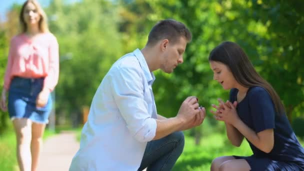 Naivní dívka obdivovat snubní prsten, zatímco její přítel při pohledu na jinou ženu — Stock video