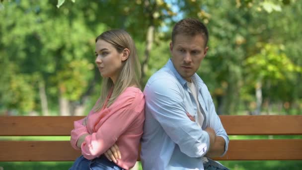 Προσβλημένο ζευγάρι κάθεται πίσω στον πάγκο στο πάρκο, κοιτάζοντας ο ένας τον άλλον, σύγκρουση — Αρχείο Βίντεο