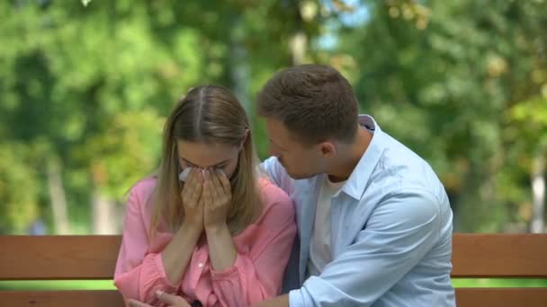 Man kramar och stöder gråtande fru i parken, relativ död, samhörighet — Stockvideo