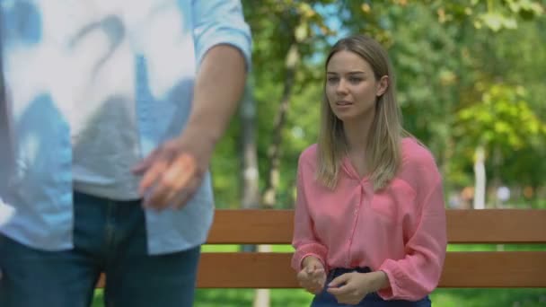 Man leaving upset girlfriend alone on bench in park, walking away, break-up — Stockvideo