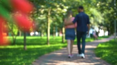 Çiçekli bir adam sevgilisini başka bir erkekle çıkarken izliyor.