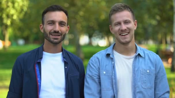 Best male friends hugging and smiling at camera outdoors, cheerful relations — Stock Video
