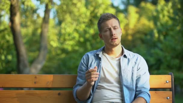 Genç adam sigara içtikten sonra zar zor öksürüyor, kronik bronşit hastalığı. — Stok video