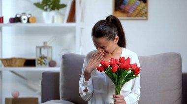Young woman holding bunch of tulips and sneezing, seasonal allergy, health clipart