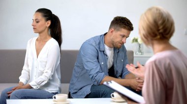 Psikolog randevusunda kanepede oturan rahatsız çift, yanlış anlama