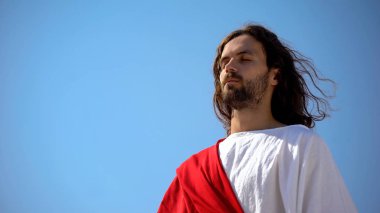 Mavi gökyüzü arka planda Tanrı 'ya dua kapalı gözleri ile aziz adam, maneviyat