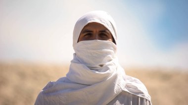 Beyaz elbiseli bedevi kameraya bakarak, İslam dini ve gelenekleri