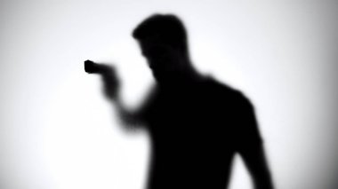 Shadow of male killer aiming gun through glass wall, contract murder, crime clipart