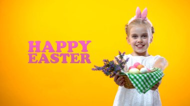Küçük kız gösteren sepet yumurta, tebrik ve gülümseyen mutlu Paskalya yazıt