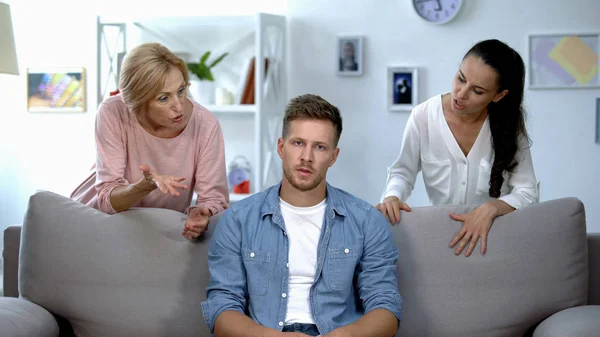 Hombre Irritado Sentado Sofá Esposa Escucha Madre Reproche Problema — Foto de Stock