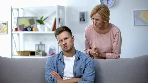 Teleurgesteld Moeder Praten Met Luie Volwassen Zoon Zittend Bank Thuis — Stockfoto