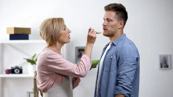 Mother Trying Feed Adult Son Spoon Overprotection Problem Protest — Stock Photo, Image