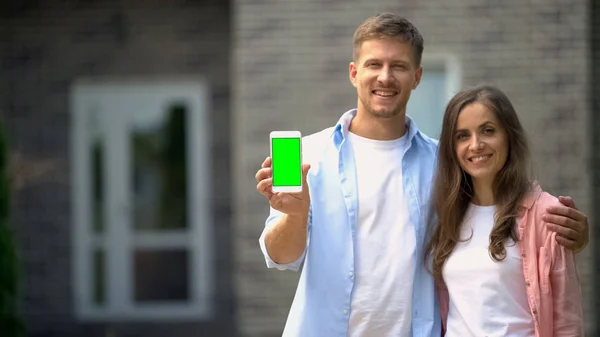 Pareja Positiva Mostrando Teléfono Inteligente Con Pantalla Verde Aplicación Reserva — Foto de Stock