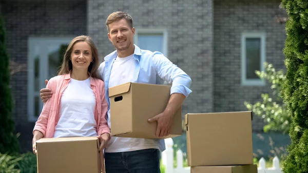 Young Family Cardboard Boxes Looking Camera Moving New House Credit — Stock Photo, Image
