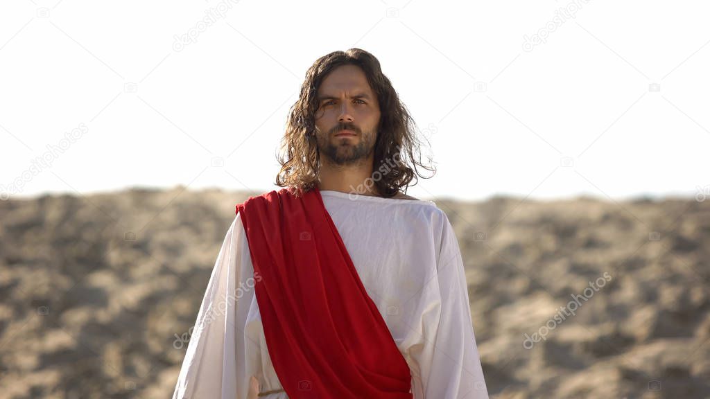 Jesus looking at camera, preaching Christian faith in desert, soul salvation