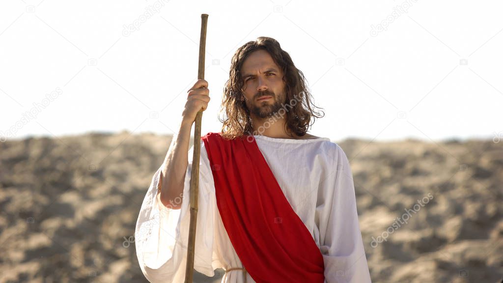 Jesus with wooden staff standing in desert, preaching Christian faith conversion