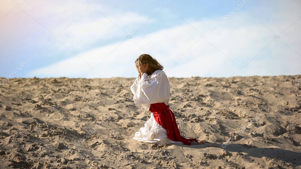 Man in robe repenting for sins, praying to God in desert, pangs of conscience