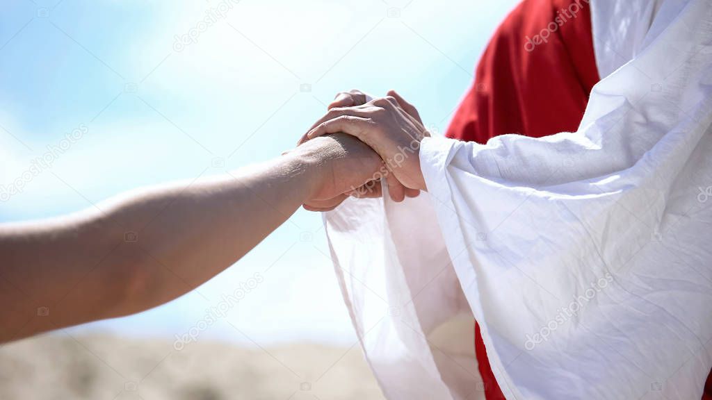 Jesus holding male hand to bless and heal Christian, religious miracle, closeup