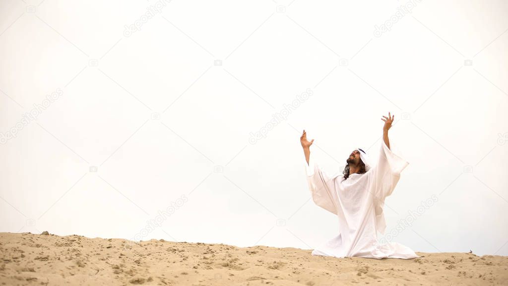 Arab raising hands to heaven, praying on knees, asking Allah to forgive sins
