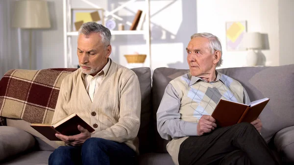 Verärgerter Alter Mann Schaut Beleidigten Freund Beim Lesen Von Buch — Stockfoto