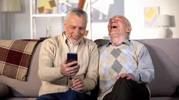Starší Muž Zobrazující Legrační Fotografii Smartphone Starým Přítelem Baví Doma — Stock fotografie