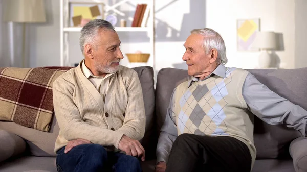 ポジティブな先輩男性がお互いを見て家のソファに座って 友情の感情 — ストック写真