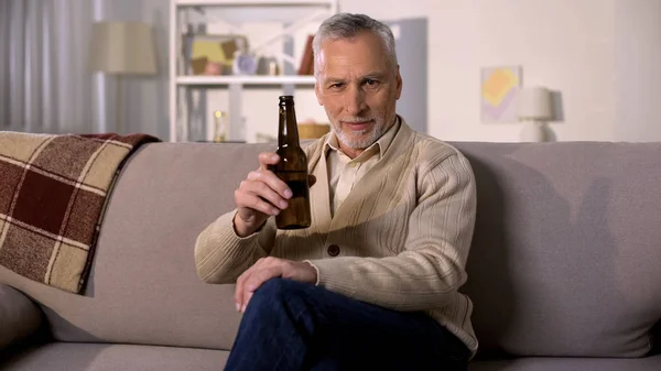 Glad Retired Male Toasting Beer Bottle Relaxing Home Sofa Alcohol — Stock Photo, Image