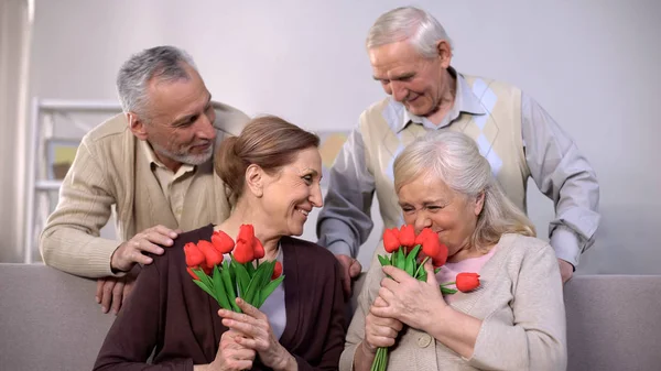 Feliz Ancianas Olfateando Tulipanes Rojos Regalo Romántico Marido Anciano Vacaciones —  Fotos de Stock