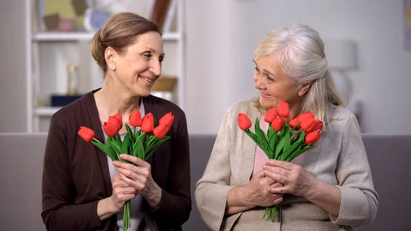 Glückliche Alte Damen Lächelnd Einander Haltend Rote Tulpen Urlaubsgrüße Geschenkt — Stockfoto