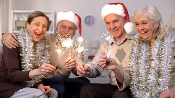 Men Santa Claus Hats Women Wrapped Tinsels Holding Sparklers New — Stock Photo, Image