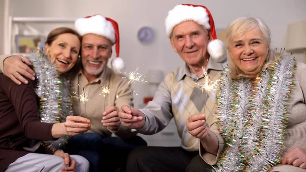 Gülümseyen Emekliler Kamera Görünümlü Kıvılcımt Noel Kutlaması Tutarak — Stok fotoğraf