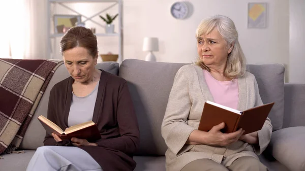 Enfadada Señora Anciana Buscando Mujer Mayor Lectura Libro Sofá Conflicto — Foto de Stock