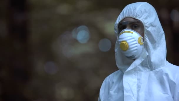 Chimiste montrant une éprouvette de laboratoire avec un liquide bleu marqué de prudence, danger — Video