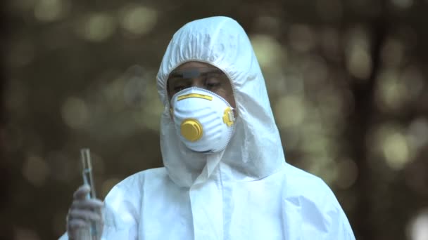 Cientista feminina segurando tubo de ensaio com marca de radiação, água infectada, ecologia — Vídeo de Stock