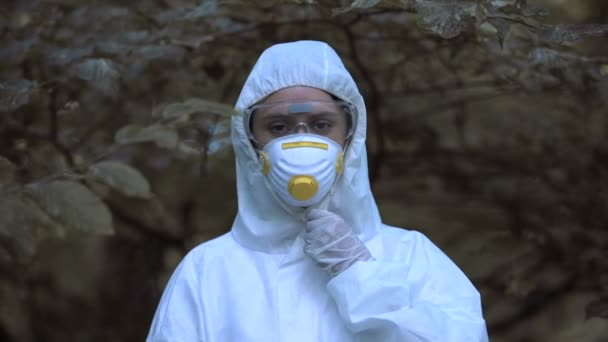 Молодая женщина снимает защитную маску дыша свободно в лесу, изменение климата — стоковое видео