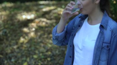Su içen kadın bardağı atıyor, küresel plastik tüketimi